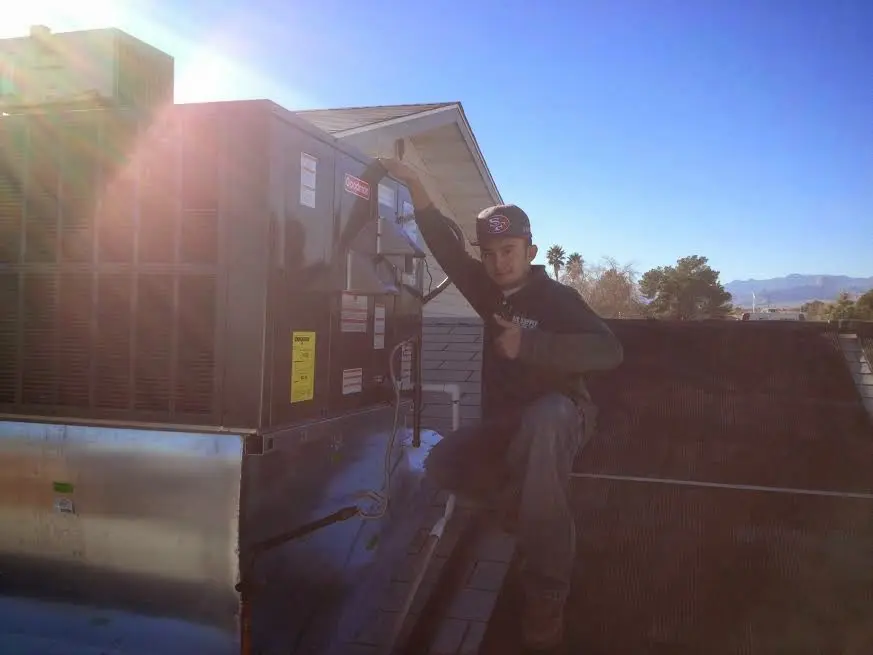 HVAC technician performing Air Duct Repair on a rooftop unit in Westminster